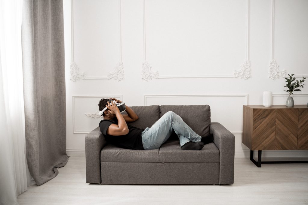 Man relaxing on couch with Smart Homes equpment- DonahTech